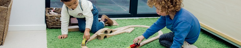 Twee jongetjes spelen met houten trein 