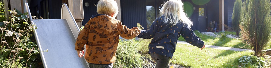Decoratieve foto van twee kinderen die elkaars hand vasthouden en lopen