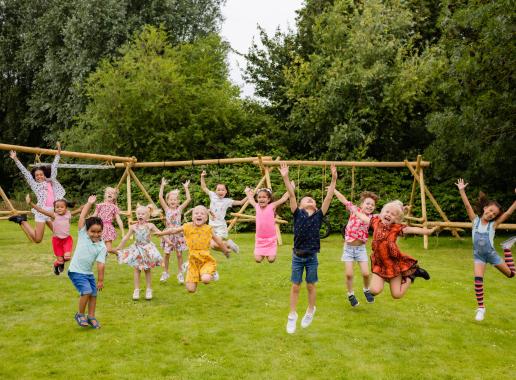 kinderen dansen en juichen op grasveld