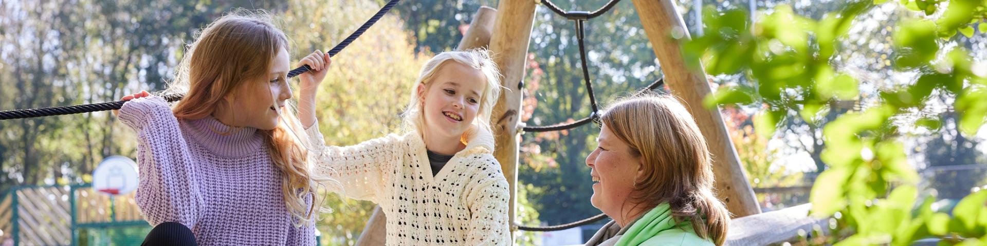 tweee meidsjes in gesprek met pedagogisch medewerker