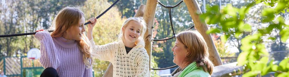 tweee meidsjes in gesprek met pedagogisch medewerker