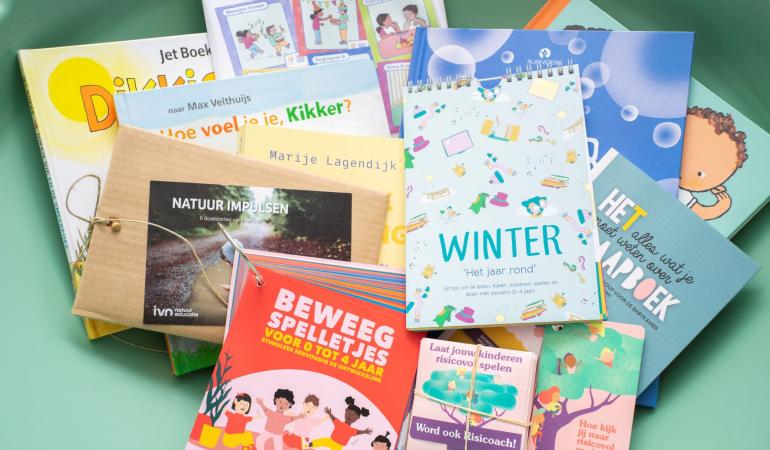 Illustratieve foto van beloningen die verdiend kunnen worden door te werken met de tool 'Wij als organisatie': leesboekjes, en educatieve spelletjes en activiteiten
