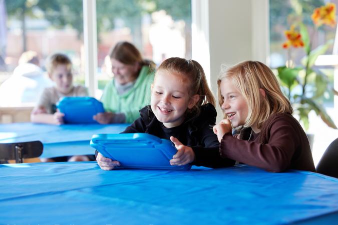 2 meisjes zitten op een tablet