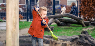 Kindje met een schep bij de kinderopvang.
